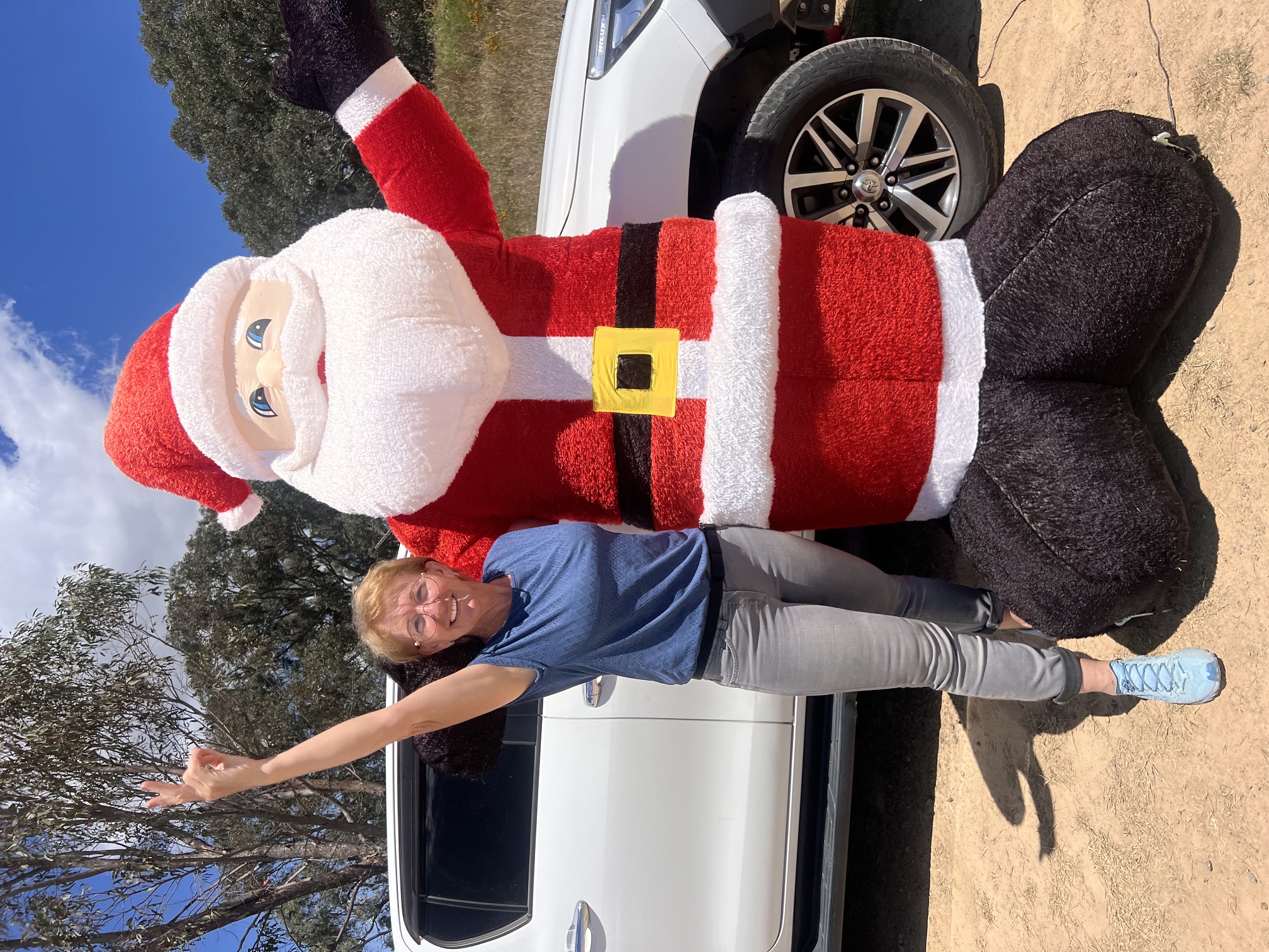 Cerina Cherries owner posing with a giant inflatable Santa beside the ute at the stall